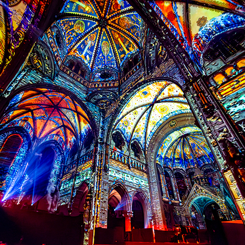 Schauspieler schwebt über em Publikum i dr Kirche.
